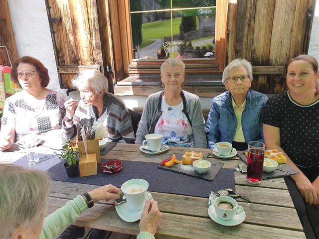 eine Gruppe älterer Frauen, die an einem Tisch sitzen
