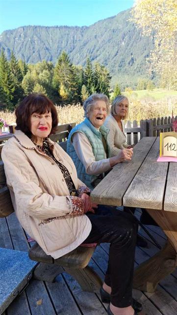 Eine Gruppe von Frauen sitzt an einem Tisch vor einem Berg