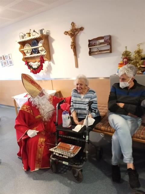 Eine Frau und ein Mann sitzen auf einer Couch mit einem Weihnachtsmann-Gewand