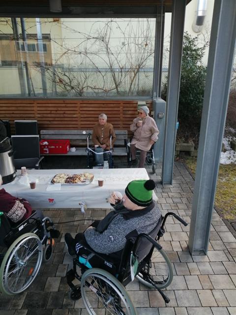 eine Person im Rollstuhl, die Essen isst