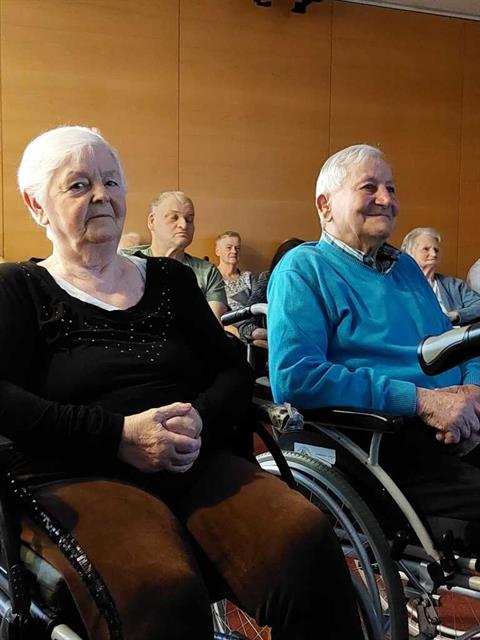 eine Person im Rollstuhl mit einer älteren Frau im Rollstuhl